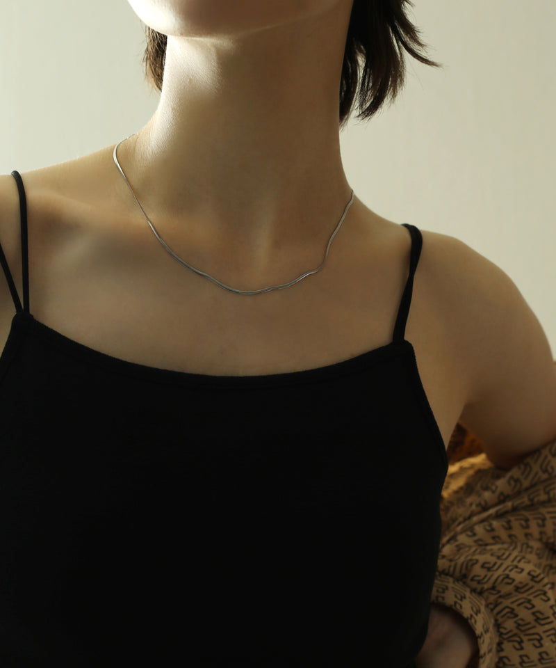 首にすっと馴染むスネークチェーンがニュアンス感を演出